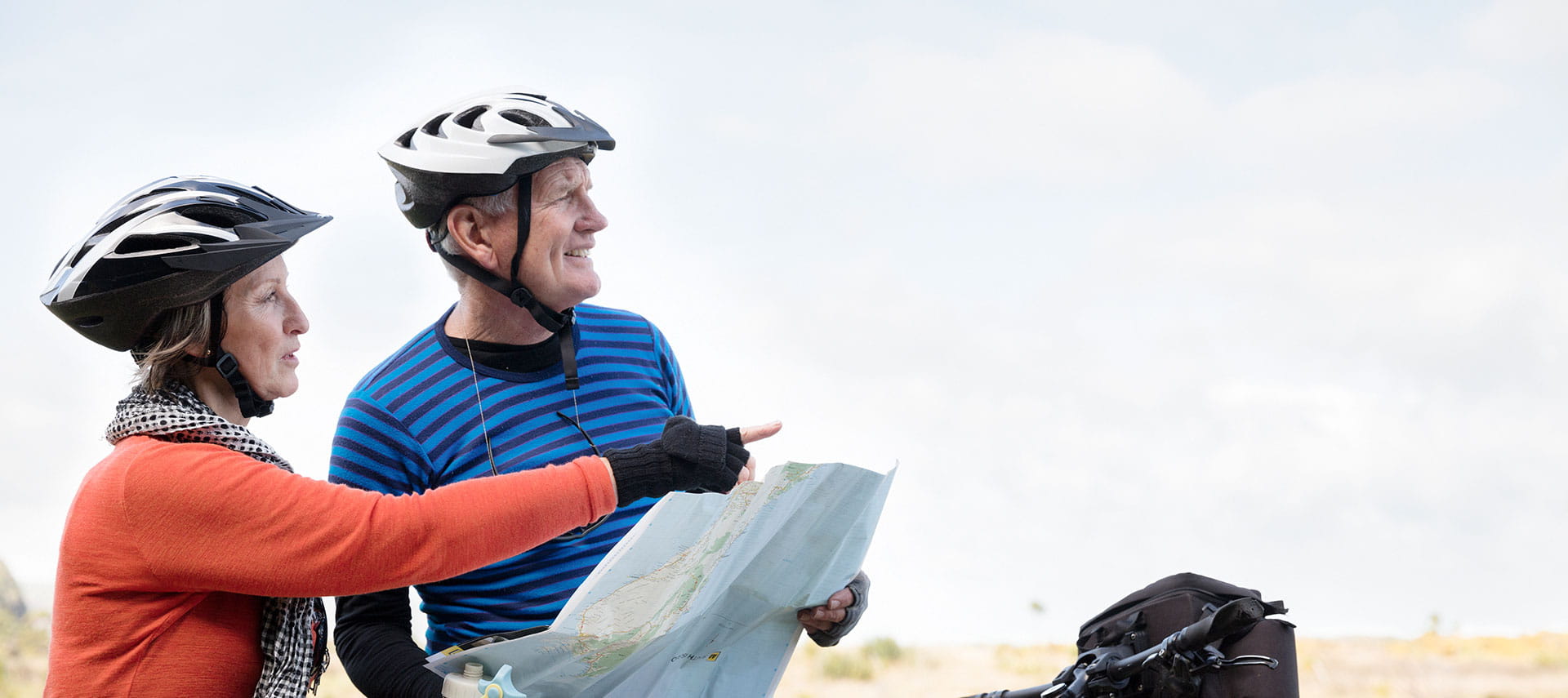 Older couple mountain biking with a map.