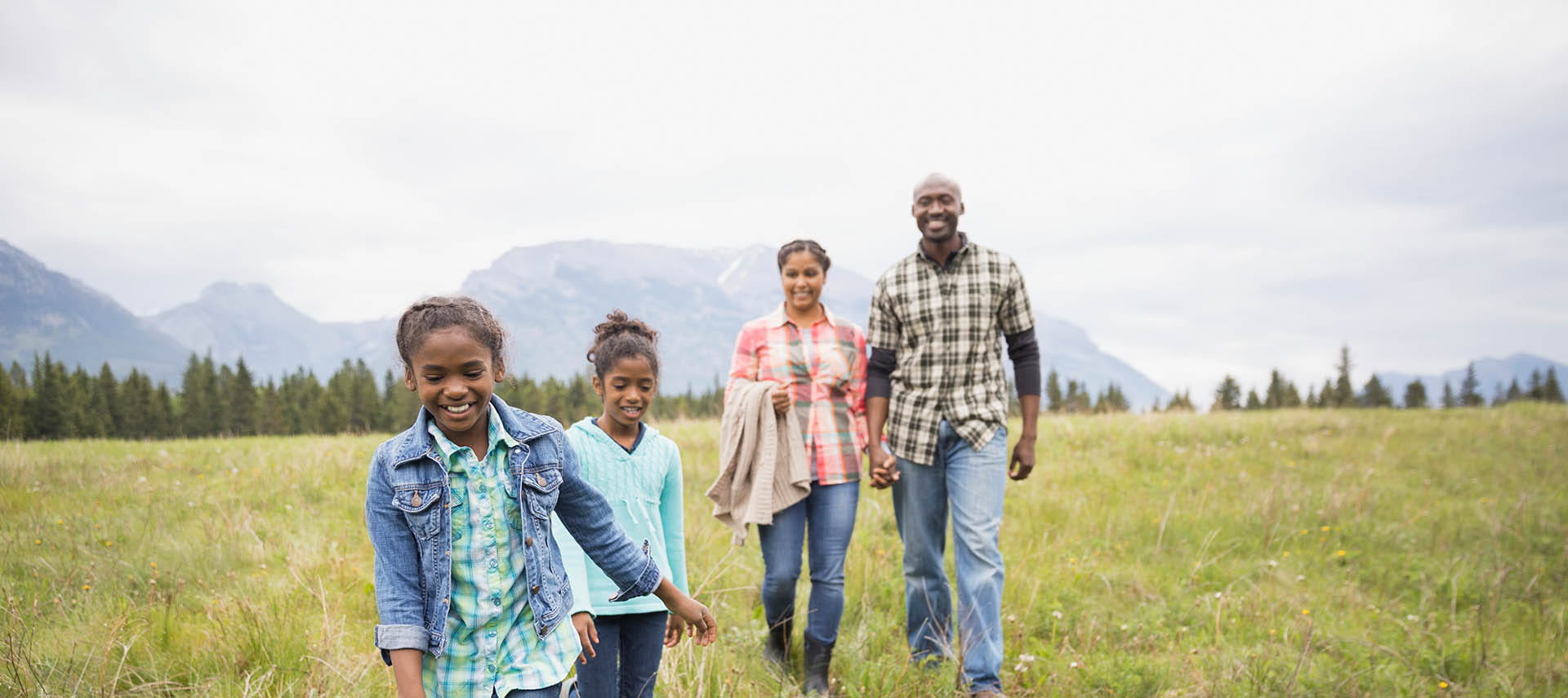Young family walking through a field.