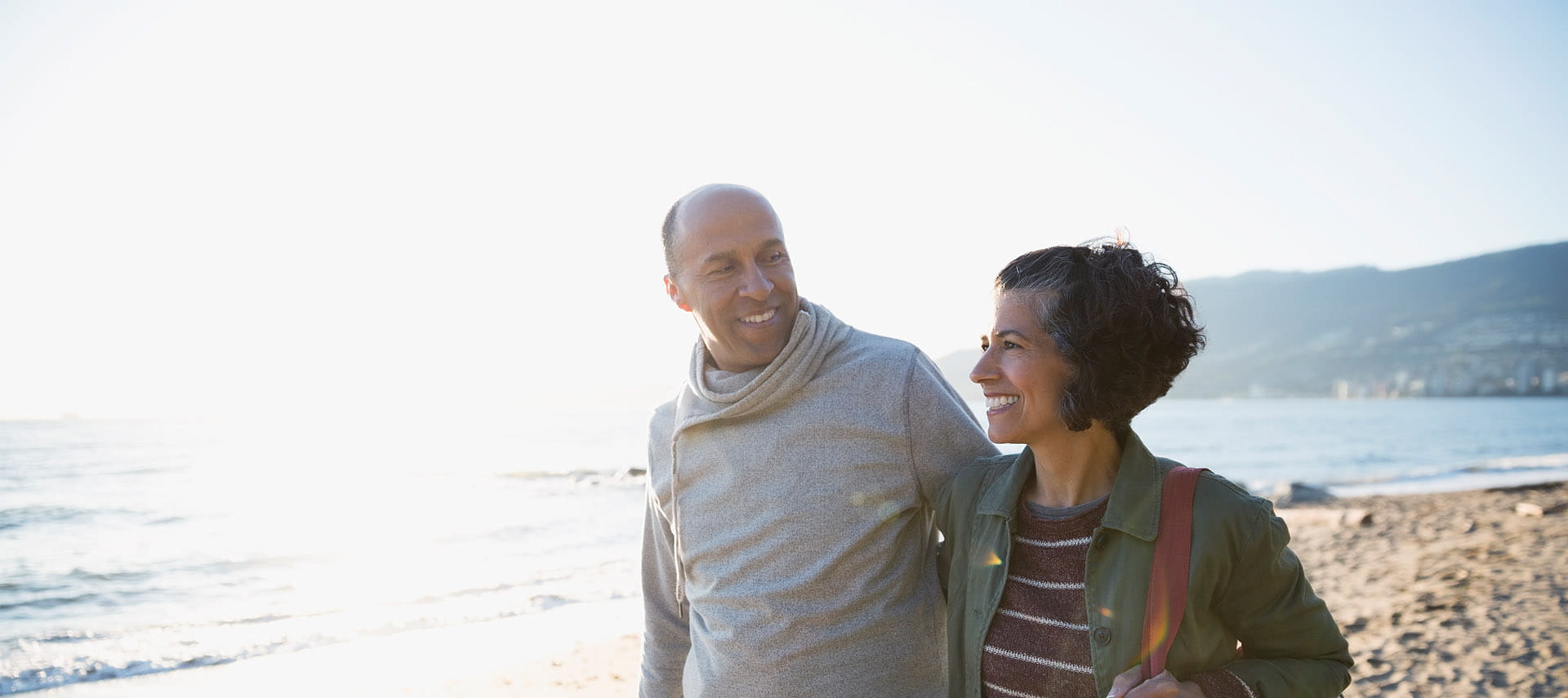 Smiling couple talking on a sunny beach.