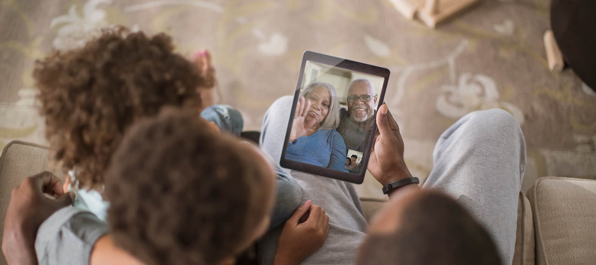 Family video chatting on tablet.